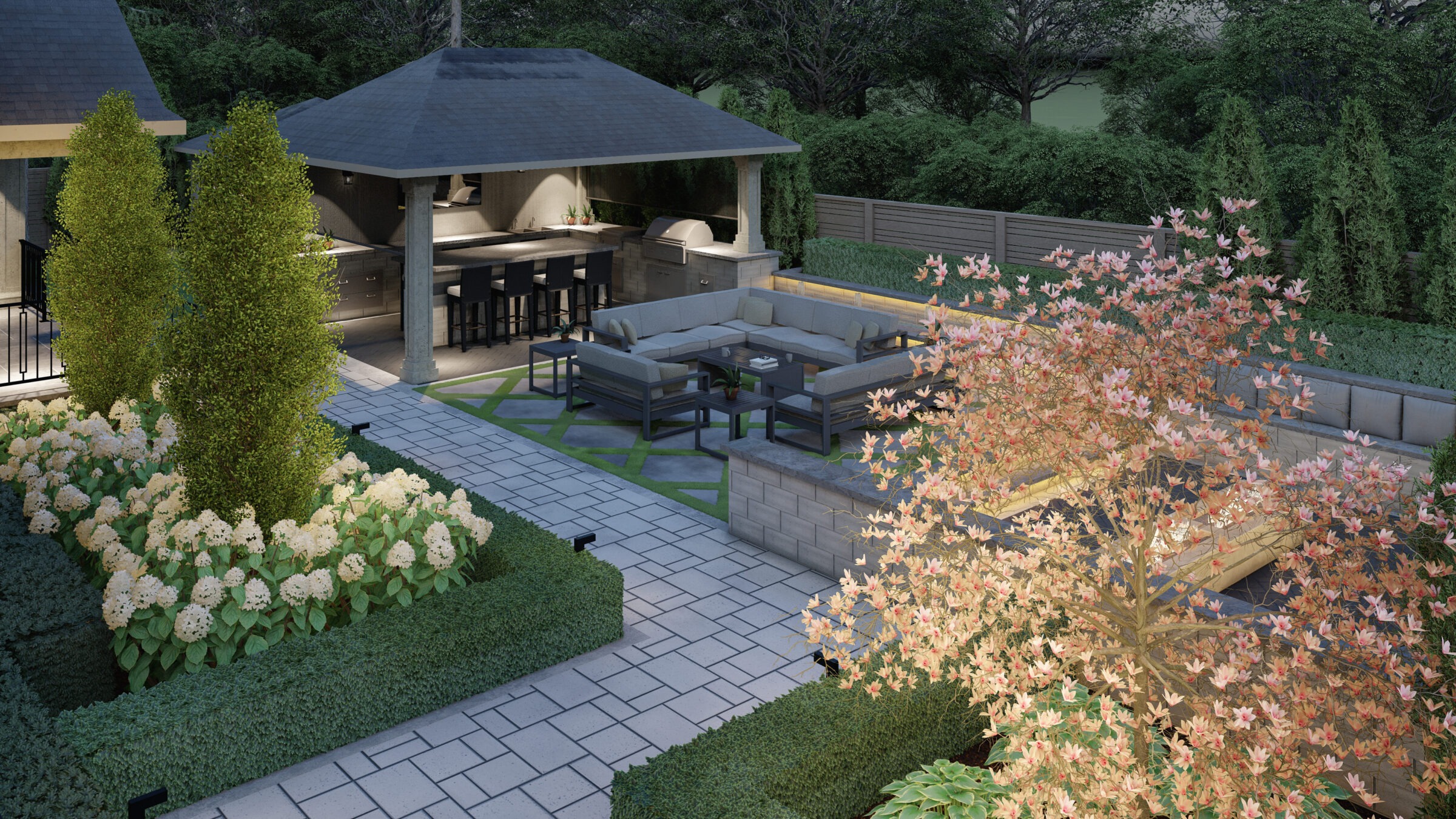 A modern backyard patio features comfortable seating, blossoming trees, and well-maintained gardens. A covered outdoor kitchen offers bar seating and appliances.